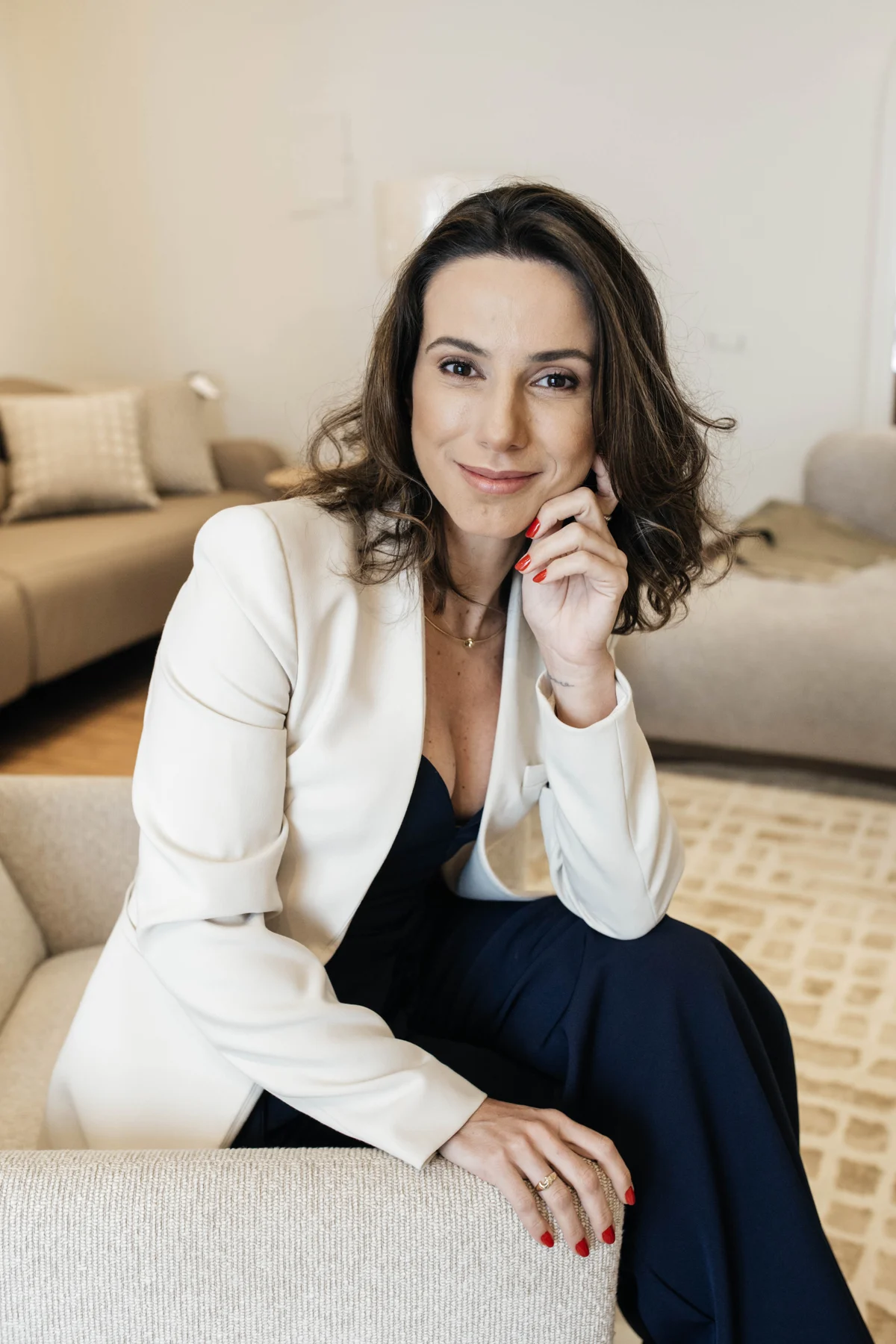 Nicole Tomazella sentada em uma poltrona